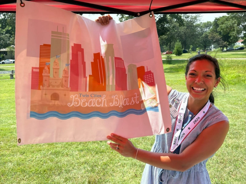Volunteer holding sign at Twins Cities community event
